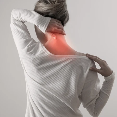 A woman holding her neck and shoulder in pain